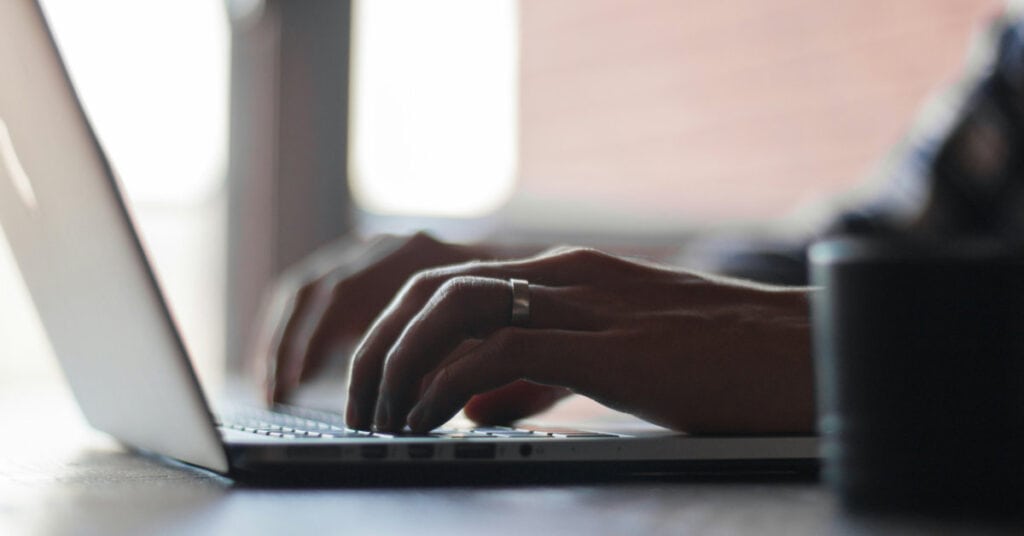 Close-up of hands typing on a laptop keyboard, symbolizing communication and connection.